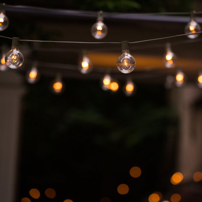  Pense em luzes pendentes penduradas em pérgulas e luminárias de piso e mesa ao ar livre usadas para iluminar as áreas de estar.